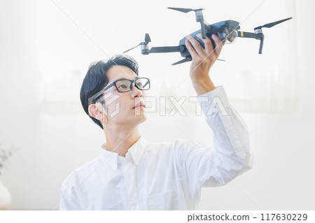 A man inspecting and maintaining a drone at home 117630229