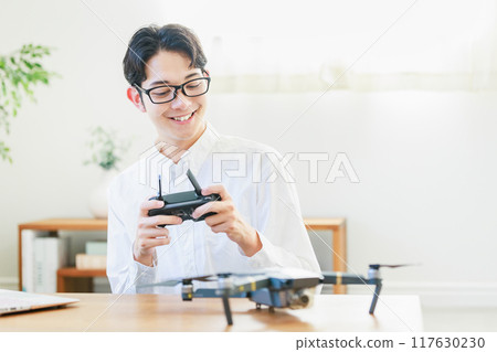 A man inspecting and maintaining a drone at home 117630230