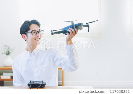 A man inspecting and maintaining a drone at home A man inspecting and maintaining a drone at home 117630231