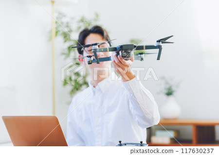 一名男子在家中檢查和維護無人機 117630237