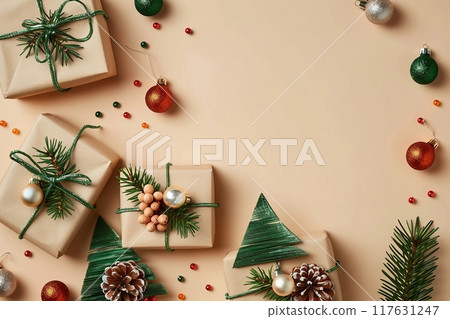 Vintage Christmas card design with craft paper gift boxes with Christmas trees and colorful Xmas balls on beige background. Flat lay. Top view. 117631247