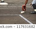 A high school baseball player picking up the ball with his glove during pre-game practice A high school baseball player picking up the ball with his glove during pre-game practice 117631682