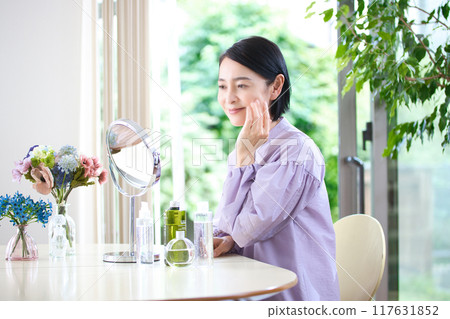 Middle-aged woman doing skin care in the living room 117631852