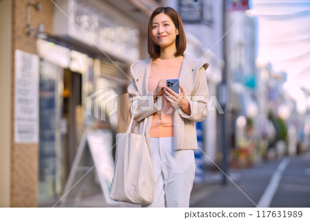 一個穿著半外套去購物的中年婦女 117631989