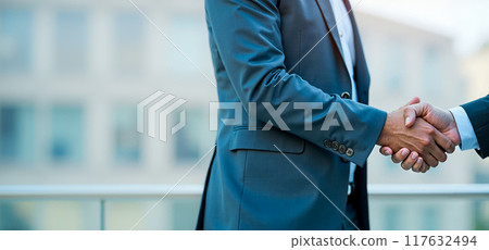 Close-up of handshake between professionals, symbolizing successful negotiation or agreement, blurred office background, copy space, corporate partnership and trust in professional environment 117632494