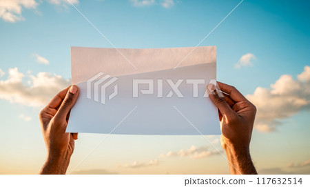 Hands holding blank white paper mockup for advertising, blue sky with clouds, perfect brochure display, invitation template, customizable clean sheet for graphic design project Hands holding blank white paper mockup for advertising, blue sky with clouds, perfect brochure display, invitation template, customizable clean sheet for graphic design project 117632514