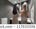 Two women touching up their makeup in the office bathroom 117633398