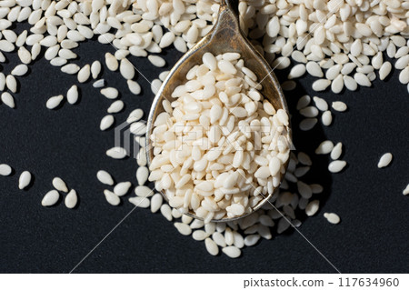 White roasted sesame seeds in a spoon 117634960