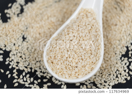 White roasted sesame seeds in a spoon 117634969