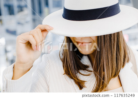 Portrait of a cheerful smiling woman wearing a stylish hat and glasses outdoors close up. 117635249