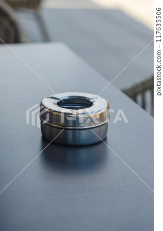 Stainless steel ashtray on wooden table. High quality photo 117635506