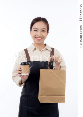 Young asian woman barista work attire happy holding a takeaway coffee cup and paper bag isolated. 117636859