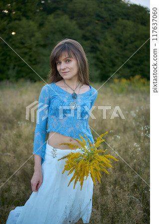 woman in whimsical aesthetic style dress in field in summer at sunset woman in whimsical aesthetic style dress in field in summer at sunset 117637060
