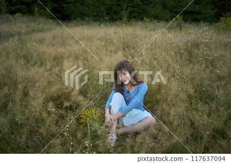 woman in whimsical aesthetic style dress in field in summer at sunset woman in whimsical aesthetic style dress in field in summer at sunset 117637094