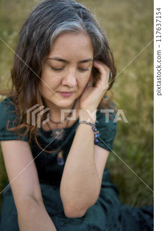 woman in whimsical aesthetic style dress in field in summer at sunset woman in whimsical aesthetic style dress in field in summer at sunset 117637154