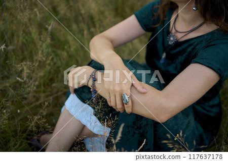 woman in whimsical aesthetic style dress in field in summer at sunset 117637178