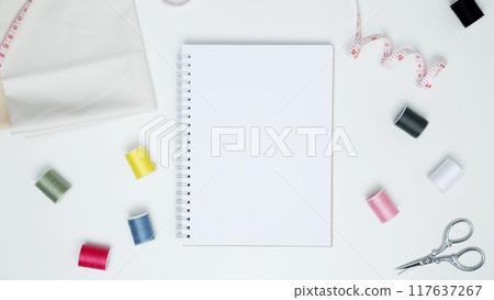 Composition with various threads and sewing accessories on white background. Mock up notebook Composition with various threads and sewing accessories on white background. Mock up notebook 117637267