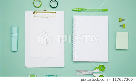 Creative flat lay mockup design of workspace. Top view composition with white notebook, to do list and stationery on green background Creative flat lay mockup design of workspace. Top view composition with white notebook, to do list and stationery on green background 117637300