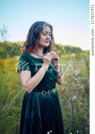 woman in whimsical aesthetic style dress in field in summer at sunset woman in whimsical aesthetic style dress in field in summer at sunset 117637451
