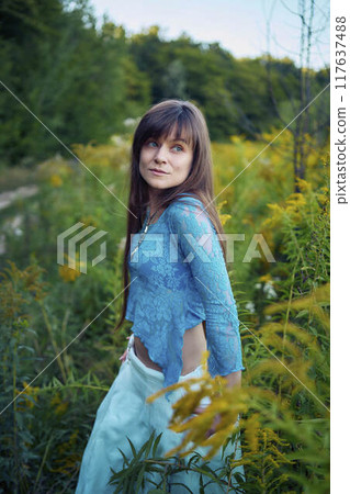 woman in whimsical aesthetic style dress in field in summer at sunset woman in whimsical aesthetic style dress in field in summer at sunset 117637488