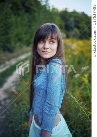 woman in whimsical aesthetic style dress in field in summer at sunset woman in whimsical aesthetic style dress in field in summer at sunset 117637489