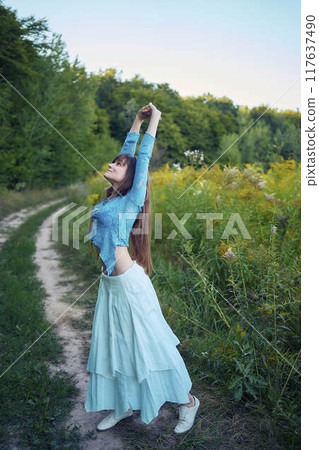 woman in whimsical aesthetic style dress in field in summer at sunset woman in whimsical aesthetic style dress in field in summer at sunset 117637490