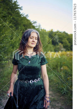 woman in whimsical aesthetic style dress in field in summer at sunset woman in whimsical aesthetic style dress in field in summer at sunset 117637623