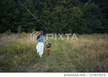 a woman in a Whimsical Aesthetic style dress with a German shepherd in a field a woman in a Whimsical Aesthetic style dress with a German shepherd in a field 117637624