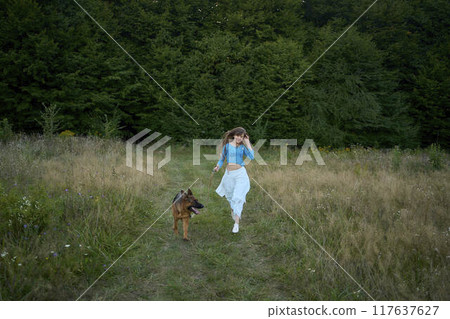 a woman in a Whimsical Aesthetic style dress with a German shepherd in a field 117637627