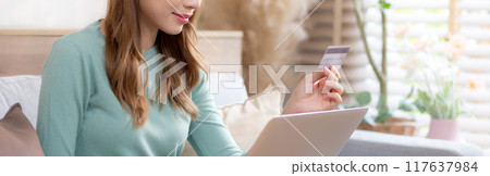 Young asian woman sitting on sofa using laptop computer shopping online with credit card. Young asian woman sitting on sofa using laptop computer shopping online with credit card. 117637984