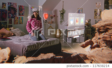 Teenage girl in AR headset looks at virtual reality holographic canyon Teenage girl in AR headset looks at virtual reality holographic canyon 117638214