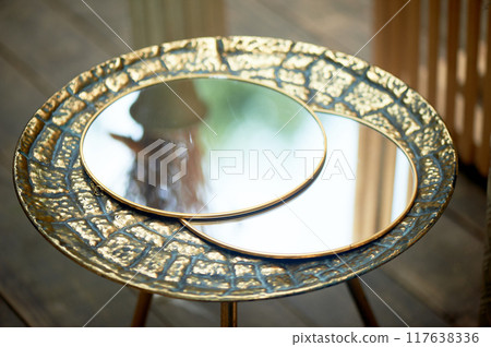 Round mirror in a golden frame. With the reflection of the sky. Beauty is in the details. 117638336