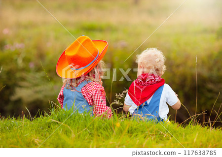 Cowboy kids playing with toy horse 117638785