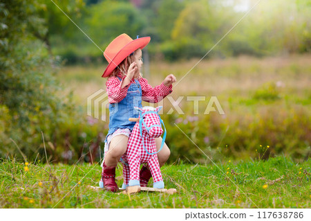 Cowboy kids playing with toy horse 117638786