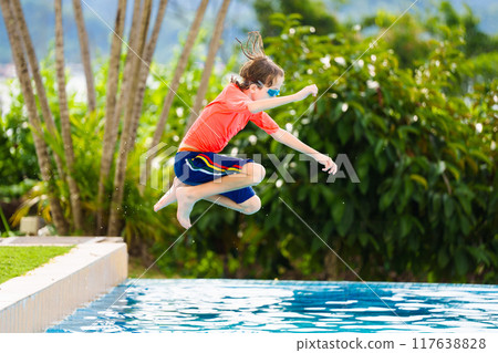 Kids jump into swimming pool. Summer water fun. 117638828