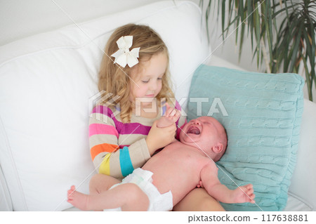 Siblings meet newborn baby Siblings meet newborn baby 117638881