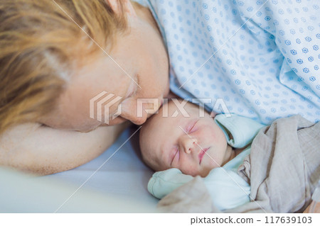 A baby lies with the mother after childbirth, resting peacefully. The serene moment captures the bond between mother and child as they begin their journey together. The hospital environment ensures a A baby lies with the mother after childbirth, resting peacefully. The serene moment captures the bond between mother and child as they begin their journey together. The hospital environment ensures a 117639103