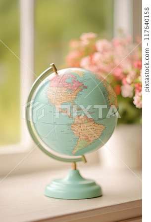 Vintage globe on wooden table with blurred flowers in the background during daytime Vintage globe on wooden table with blurred flowers in the background during daytime 117640158