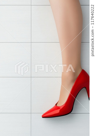 Elegant red high-heeled shoe on display against a neutral background Elegant red high-heeled shoe on display against a neutral background 117640222