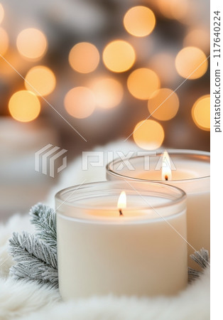 Cozy winter setting with lit candles and pine cones surrounded by soft white fabric Cozy winter setting with lit candles and pine cones surrounded by soft white fabric 117640224