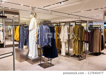 A showcase with mannequins in a clothing store in a shopping center. A showcase with mannequins in a clothing store in a shopping center. 117640477