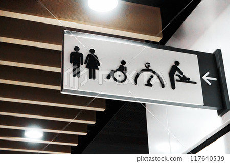 A white and black sign for the toilet and prayer room is on the wall. 117640539