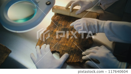 Scientists open ancient Egyptian papyrus on the table in archaeological lab 117640604