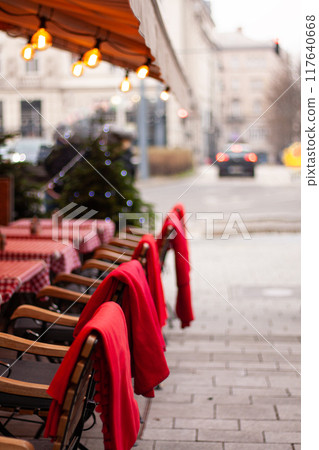 the outdoor cafe is decorated for Christmas, red blankets on the chairs the outdoor cafe is decorated for Christmas, red blankets on the chairs 117640668