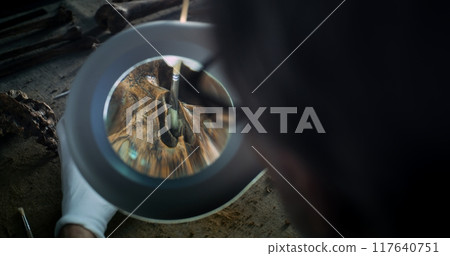 Mature archaeologist cleans skull of ancient prehistoric human with tools 117640751