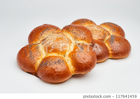Freshly baked braided challah bread topped with sesame and poppy seeds, perfect for any meal Freshly baked braided challah bread topped with sesame and poppy seeds, perfect for any meal 117641459