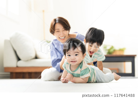 Parent and child playing in the living room 117641488