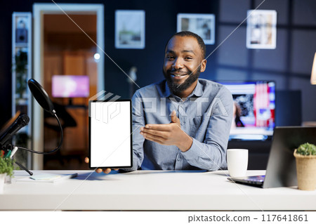 Technology expert at home holding newly launched isolated screen tablet in hand, presenting camera and screen specs. Media star doing mockup digital device review for viewers 117641861