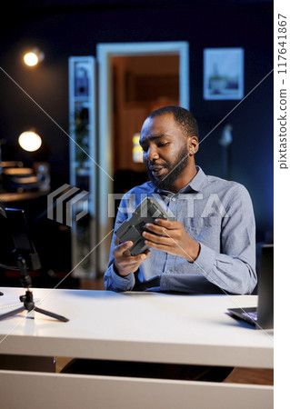 Influencer reviewing V mount battery, expressing dissatisfaction with subpar quality. Content creator shooting video for online channel, displeased with professional lithium accumulator performance Influencer reviewing V mount battery, expressing dissatisfaction with subpar quality. Content creator shooting video for online channel, displeased with professional lithium accumulator performance 117641867