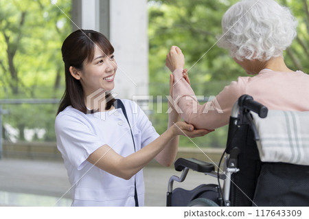 Physiotherapist rehabilitating a senior woman 117643309